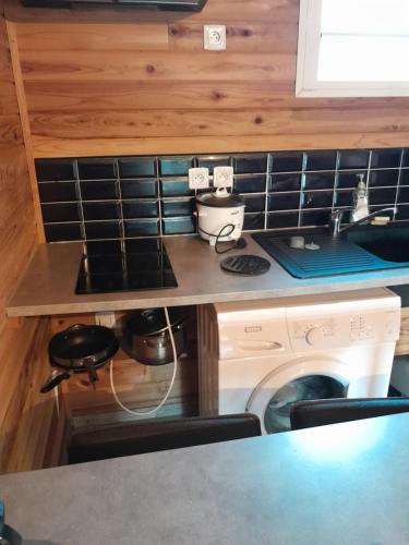 a kitchen with a stove and a washing machine at CHALET DE LISE in Bras-Panon