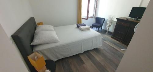 um quarto com uma cama, uma secretária e uma cadeira em La Casita villa avec piscine prés d'Uzes em Saint-Laurent-la-Vernède