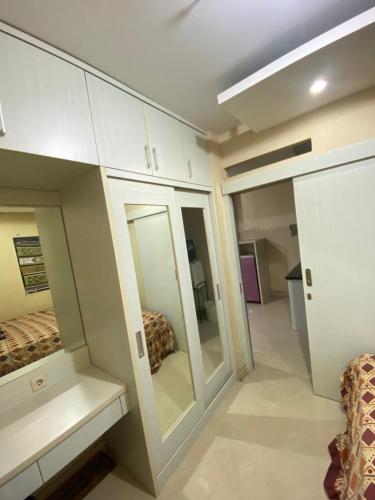 a room with mirrors and a room with a bed at Cibubur Village Apartemen by Ar-Ramadhan in Cibubur