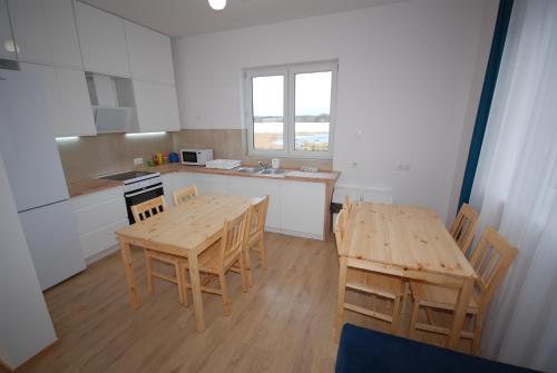 a kitchen with a wooden table and chairs and a table and a table at Pęglity jezioro in Gietrzwałd