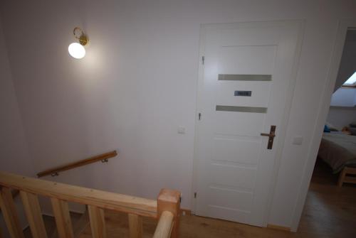 a hallway with a white door and a bed at Pęglity jezioro in Gietrzwałd