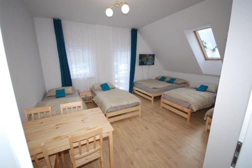 a room with three beds and a table at Pęglity jezioro in Gietrzwałd
