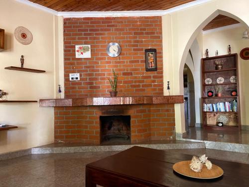 a brick fireplace in a living room with a table at Toiwo Residence Arusha in Arusha