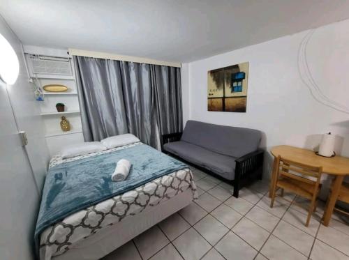 1 dormitorio con 1 cama, 1 silla y 1 mesa en Verdemar Apts, en San Juan