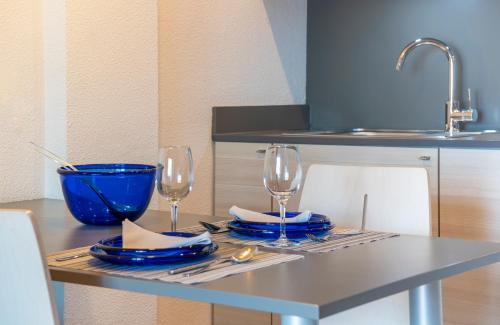 a table with two glasses and plates and a sink at Almirall Apartaments in Lloret de Mar