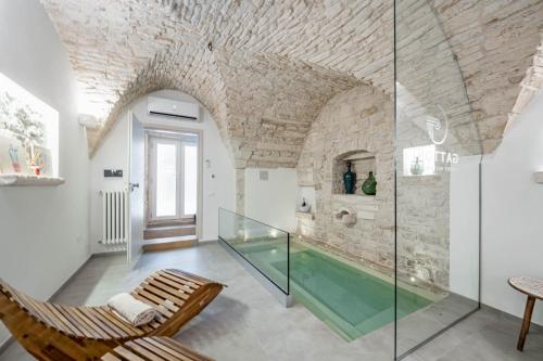 une chambre avec un aquarium en verre dans un mur en pierre dans l'établissement Gattoni Suite by Rentbeat, à Martina Franca