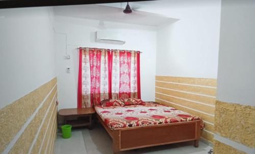 Rāmgarh的住宿－CLASSIC GUEST HOUSE，一张小床,位于一个红色窗帘的房间