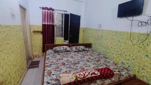 Rāmgarh的住宿－CLASSIC GUEST HOUSE，卧室配有一张床铺,位于一个黄色墙壁的房间