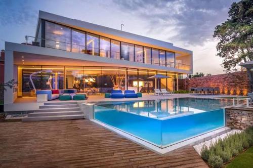a large house with a swimming pool in front of it at Total confort in Porto Alegre