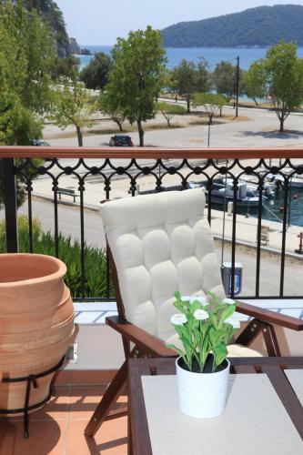 a white chair sitting on a balcony with a plant at Lina A & M in Neo Klima