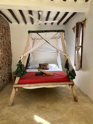 a bedroom with a canopy bed in a room at Dreamland Bungalows Michamvi Kae in Michamvi