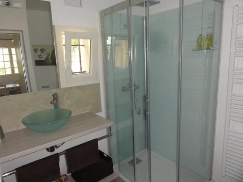 a bathroom with a glass shower with a sink at Guestazur Draguignan in Draguignan