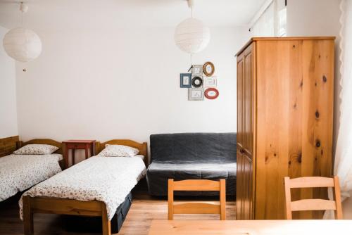 a room with a bed and a couch and a chair at Leśne Apartamenty in Zieleniec