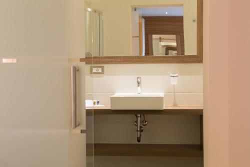 a bathroom with a sink and a mirror at Astor Hotel in Schenna