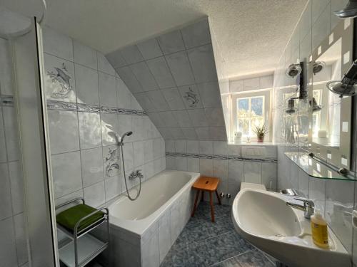 een witte badkamer met een bad en een wastafel bij Ferienwohnung Biohof Laußnitzer in Rennweg in Rennweg