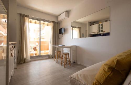 a bedroom with a bed and a desk and a window at Studio cabine Les Rives de la Favière piscine et tennis les pieds dans l'eau in Bormes-les-Mimosas