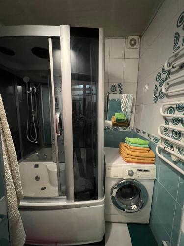 y baño pequeño con lavadora. en Garden House, en Almaty