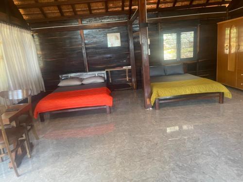 a room with two beds in a wooden cabin at Gỗ Homestay khu sinh thái Akodhong và trung tâm BMT in Buon Ma Thuot