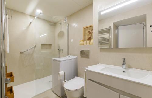 y baño con aseo, lavabo y ducha. en Apartamentos do Mar - Pikis Flat, en Funchal