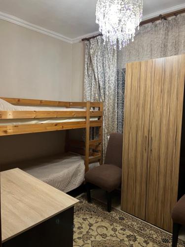 a bedroom with a bunk bed and a chair and a chandelier at Garden House in Almaty