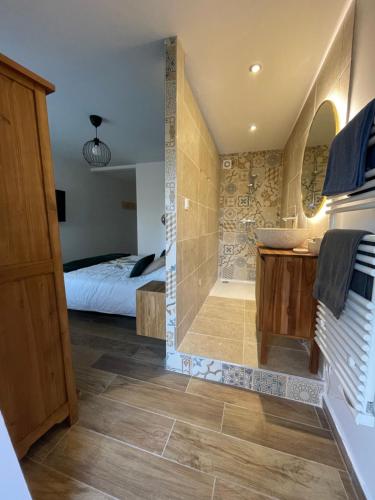 a bathroom with a shower and a bed in a room at Chez Gabriel et Sophie in Pérouges