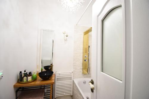 W łazience znajduje się umywalka, wanna i lustro. w obiekcie Homey Luxury- entire house, free parking, yard w Klużu-Napoce