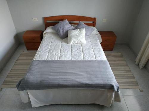 un letto con due cuscini sopra in una camera da letto di Piso luminoso con enorme terraza y buenas vistas a Carballo