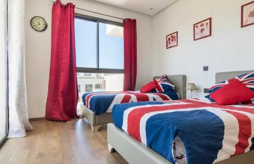 two beds in a bedroom with red white and blue at résidence hivernage, couples mariés in Agadir