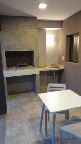 a room with a table and two chairs and a fireplace at Acacias Mina Clavero in Mina Clavero