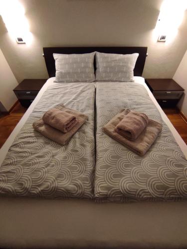 ein Bett mit zwei Kissen und zwei Handtüchern darauf in der Unterkunft Apartma Laura in Ankaran