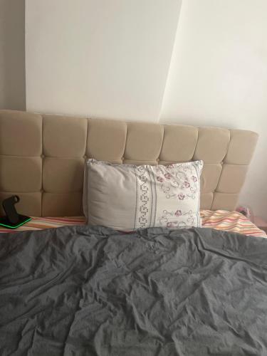 a bed with a headboard and two pillows on it at Weltek in Güllüce