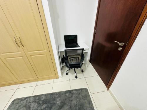 a desk with a laptop computer on it next to a door at Deluxe GIRLS HOSTEL in Dubai