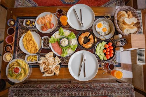 une table remplie de assiettes de nourriture sur une table dans l'établissement Zeus Cave Suites, à Gorëme