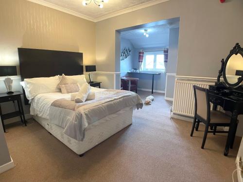 a bedroom with a large bed and a desk and a desk at The Lawns Hotel in Derby