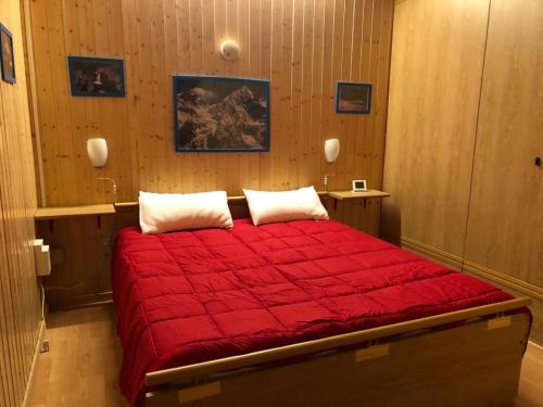 a bedroom with a large red bed with two pillows at Appartamento Lidia piano terra in Santa Maria Maggiore