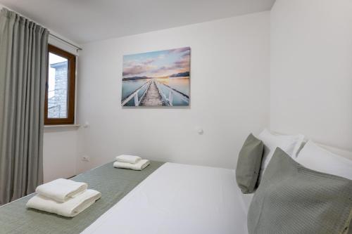 - une chambre blanche avec 2 lits et une fenêtre dans l'établissement Apartment ALEX in Kaštel Novi, à Kaštela