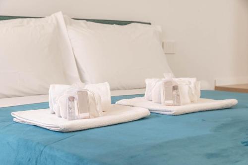 duas toalhas sentadas em cima de uma cama em We Home - Romeo&Giulietta Luxury Retreat em Verona