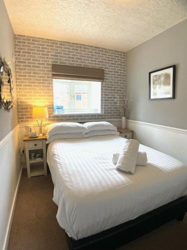 a bedroom with a large white bed and a window at The Lawns Hotel in Derby