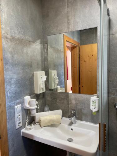 uma casa de banho com um lavatório e um espelho em Moserhof em Schladming