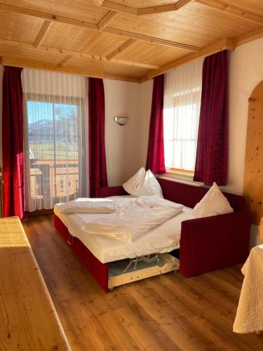 a bedroom with a bed in a room with red curtains at Moserhof in Schladming