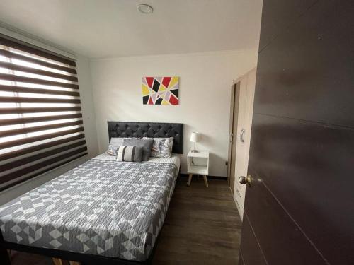 Habitación pequeña con cama y escritorio. en Amplia Casa en Condominio, en La Serena