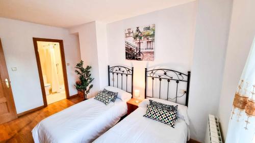 - une chambre avec 2 lits et un miroir dans l'établissement El Alce del Pilar ComoTuCasa, à Huesca