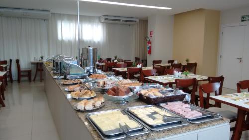 a buffet line with food on it in a restaurant at Atalaia Apart Hotel in Aracaju