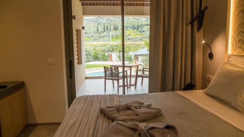 a bedroom with a bed with a view of a patio at Alissachni SeaSide Hotel in Derveni