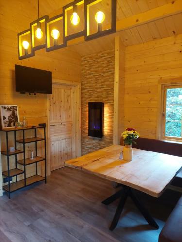 uma sala de jantar com uma mesa de madeira e uma televisão em Tiny House am Teich em Garnsdorf