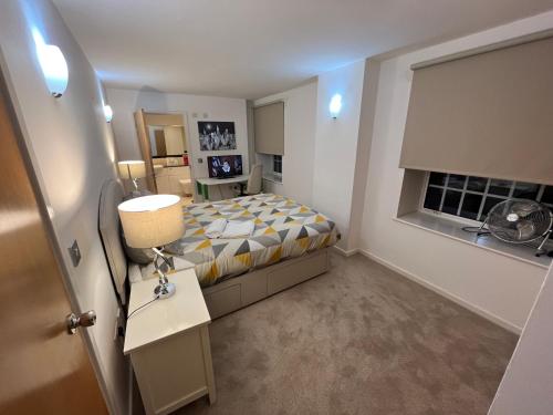 a small bedroom with a bed and a lamp at Ensuite Room in Royal Victoria Excel O2 Arena London in London