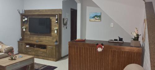 Una televisión o centro de entretenimiento en Pousada Canoa dos Anjos suítes
