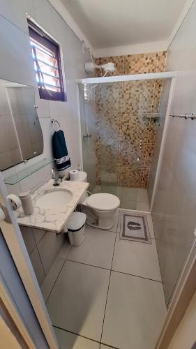 a bathroom with a toilet and a sink and a shower at Sol & Vento Chalés in Touros