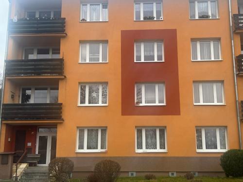 an orange building with white windows at Rekreační byt 3+1 in Železná Ruda