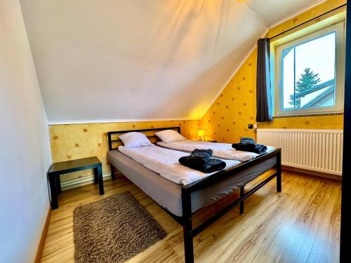 a bedroom with a bed and a window at Domek Monte Black z jacuzzi i sauną fińską in Stronie Śląskie